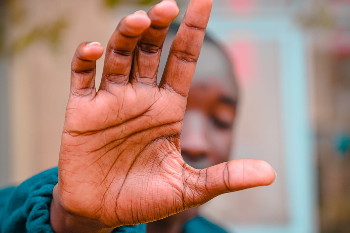 a close up of a person holding their hand up