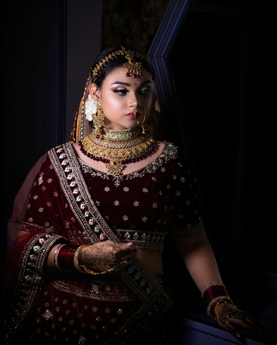 a woman in a red and gold bridal outfit